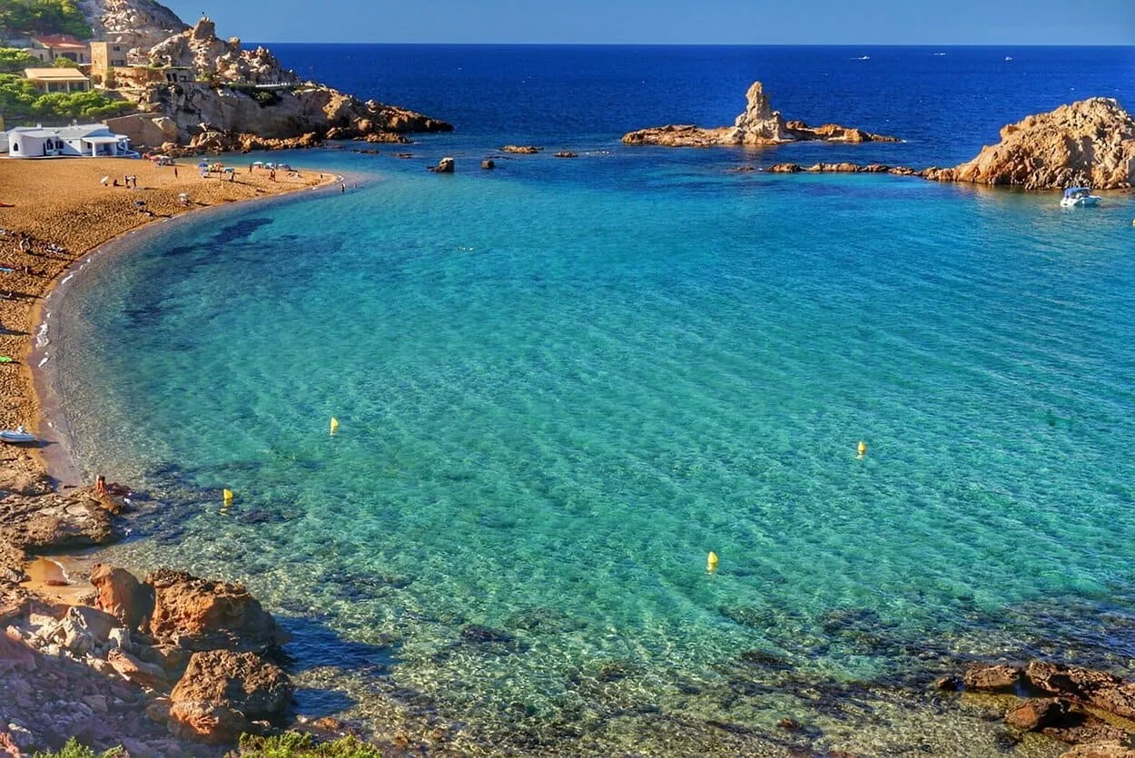 Cala Pregonda (Menorca): arena rojiza e islotes en la costa norte.